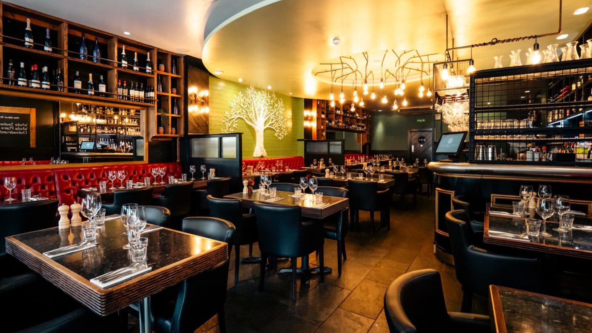 The dining room with the olive tree wall and the bar