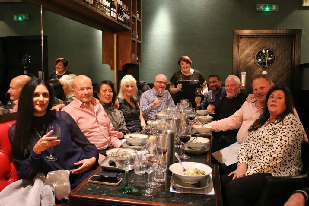A big group gathered around one long table at The Olive Tree